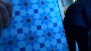 Blue geometric patterned panel beside partially visible people